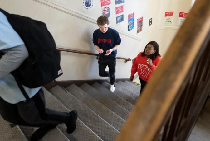 Deering High School seniors Colby Drabik, left, and Clementina Mongawalk walk up the stairs at the high school at the end of the school day on Monday. Both experienced the earlier school start time as freshmen and say that the later school start time is hugely beneficial. Gregory Rec/Staff Photographer