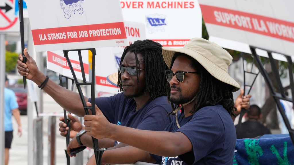 Dockworkers from Port Miami display signs at a picket line, Thursday, Oct. 3, 2024, in Miami.  (AP Photo/Marta Lavandier)