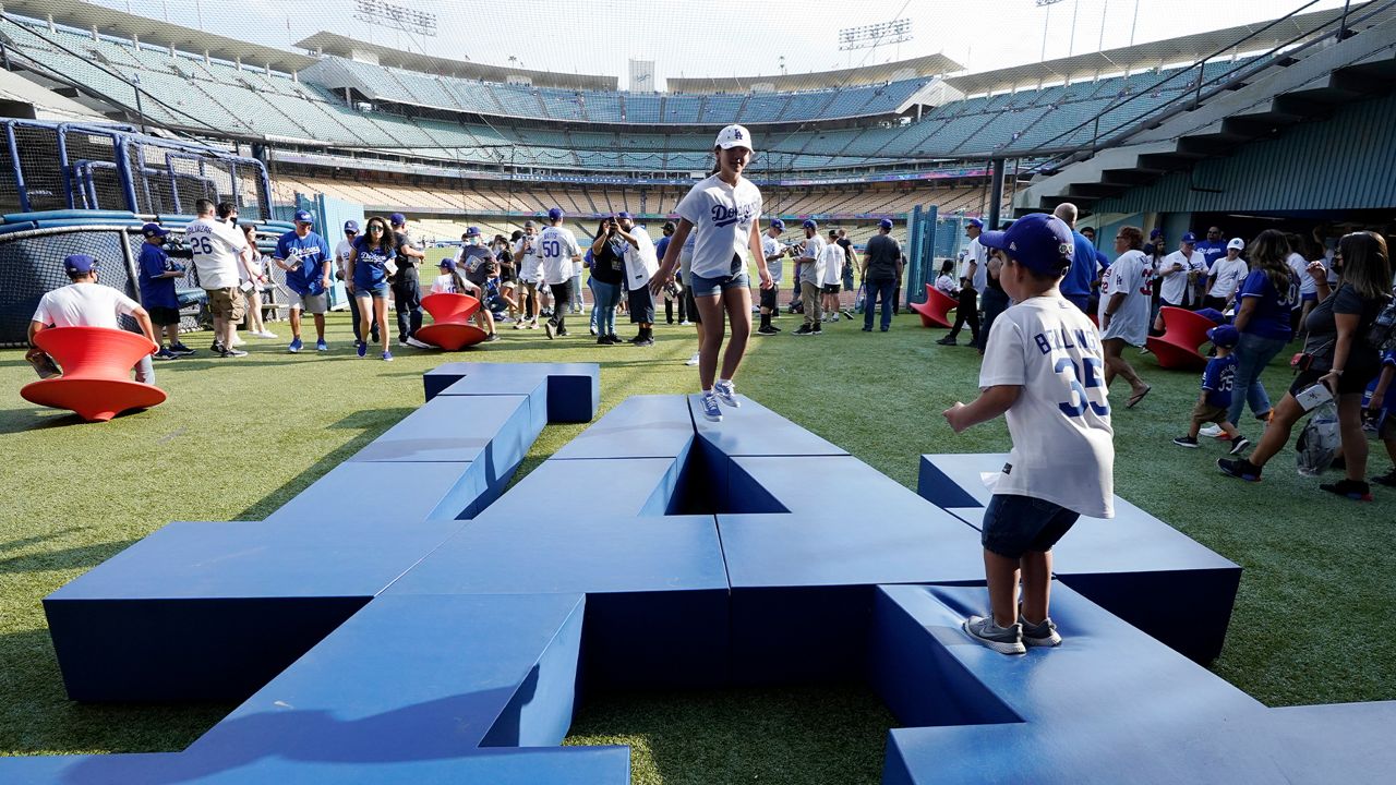 Kids play in the Centerfield Plaza area at Dodger Stadium prior to a baseball game between the Los Angeles Dodgers and the Philadelphia Phillies, June 15, 2021, in LA. (AP Photo/Mark J. Terrill)