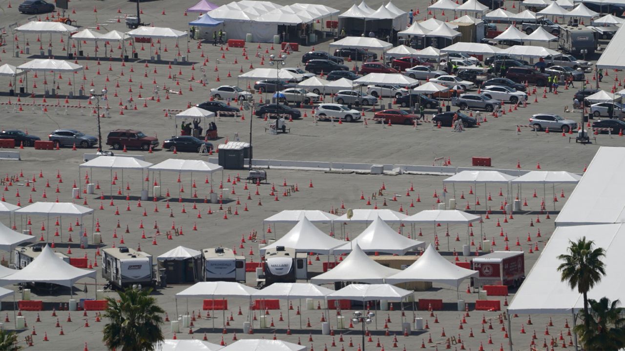 File - In this Saturday, April 10, 2021, file photo motorists sit inside their vehicles as they wait their turn to be inoculated with a COVID-19 vaccine at Dodger Stadium parking lot in Los Angeles. (AP Photo/Damian Dovarganes, File)