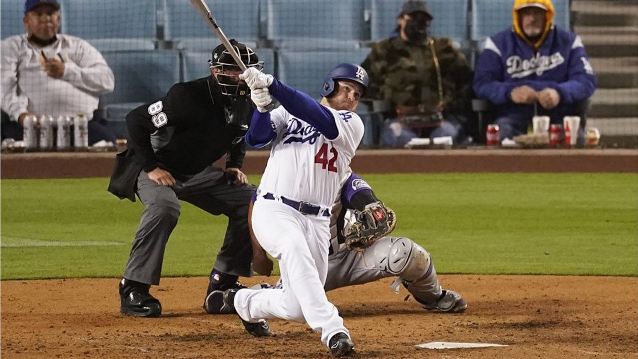 Los Angeles Dodgers' Max Muncy hits a home run during the seventh inning of a baseball game against the Colorado Rockies Thursday, April 15, 2021, in Los Angeles. Chris Taylor and Justin Turner also scored. (AP Photo/Ashley Landis)