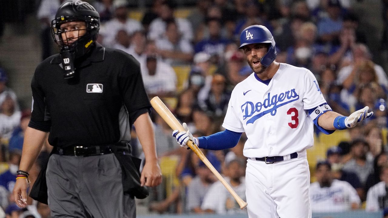 Los Angeles Dodgers' Chris Taylor, right, talks at home plate umpire Manny Gonzalez after striking out during the seventh inning of a baseball game against the Philadelphia Phillies Wednesday, June 16, 2021, in Los Angeles. (AP Photo/Mark J. Terrill)