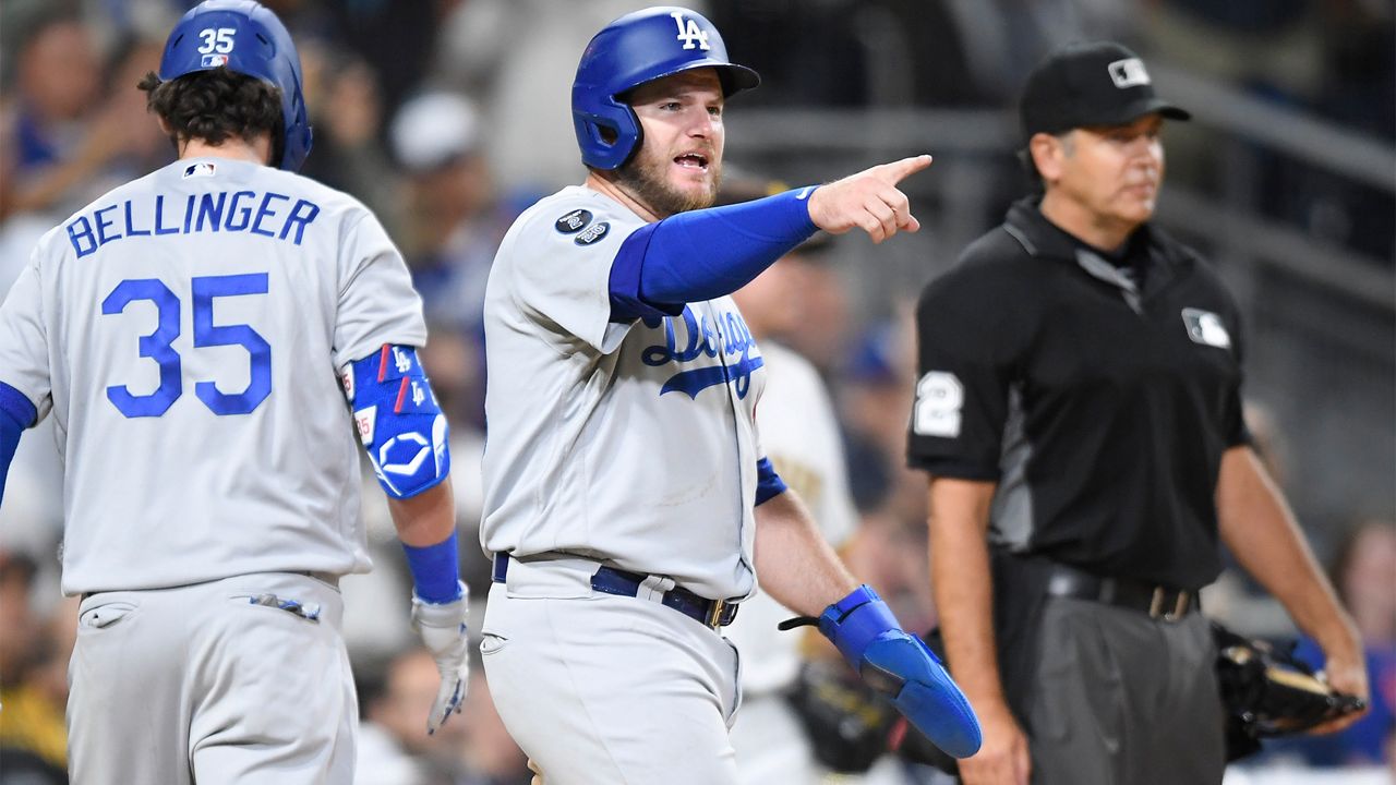 Los Angeles Dodgers' Max Muncy (13) points out to Justin Turner (10) after scoring during the eighth inning of a baseball game against the San Diego Padres Wednesday, June 23, 2021, in San Diego. (AP Photo/Denis Poroy)