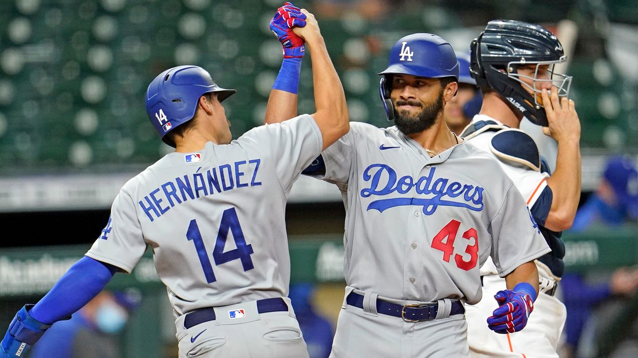 Los Angeles Dodgers' Edwin Rios (43) celebrates with Enrique Hernandez (14) after both scored on Rios' two-run home run against the Houston Astros during the 13th inning of a baseball game Wednesday, July 29, 2020, in Houston. (AP Photo/David J. Phillip)