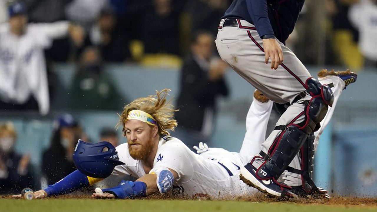 Los Angeles Dodgers' Justin Turner scores past Atlanta Braves catcher Travis d'Arnaud on a single by AJ Pollock during the eighth inning of a baseball game Wednesday, Sept. 1, 2021, in Los Angeles. (AP Photo/Marcio Jose Sanchez)