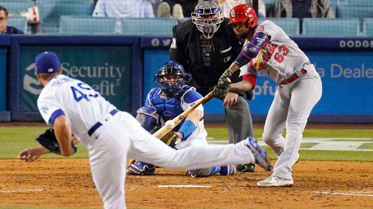St. Louis Cardinals' Edmundo Sosa, right, hits and RBI single as Los Angeles Dodgers relief pitcher Blake Treinen, left, and catcher Will Smith, second from left, watch along with home plate umpire Hunter Wendelstedt during the ninth inning of a baseball game Tuesday, June 1, 2021, in Los Angeles. (AP Photo/Mark J. Terrill)