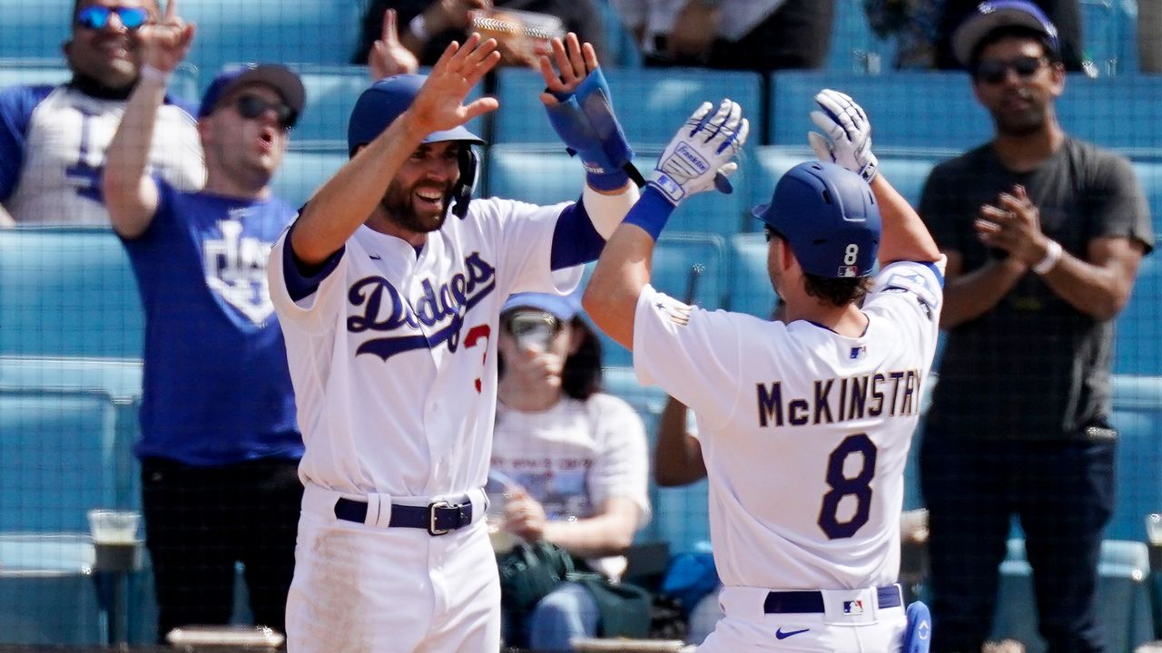 Los Angeles Dodgers' Zach McKinstry, right, is congratulated by Chris Taylor after hitting a two-run home run during the seventh inning of a baseball game against the Washington Nationals Sunday, April 11, 2021, in Los Angeles. (AP Photo/Mark J. Terrill)