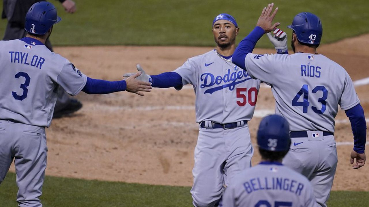 Los Angeles Dodgers' Mookie Betts, left, dives back to first on a