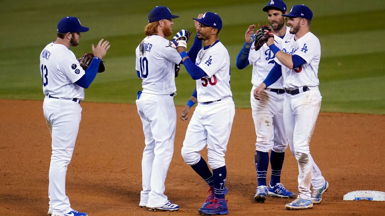 Los Angeles Dodgers celebrate a 4-2 win over the Arizona Diamondbacks in a baseball game Wednesday, May 19, 2021, in Los Angeles. (AP Photo/Marcio Jose Sanchez)