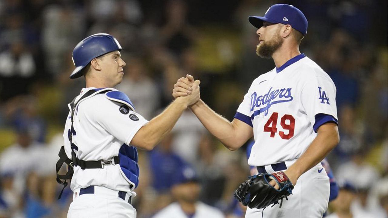 Los Angeles Dodgers catcher Will Smith, left, and relief pitcher Blake Treinen (49) celebrate after a 4-1 win over the New York Mets in their baseball game Thursday, Aug 19, 2021, in Los Angeles. (AP Photo/Ashley Landis)