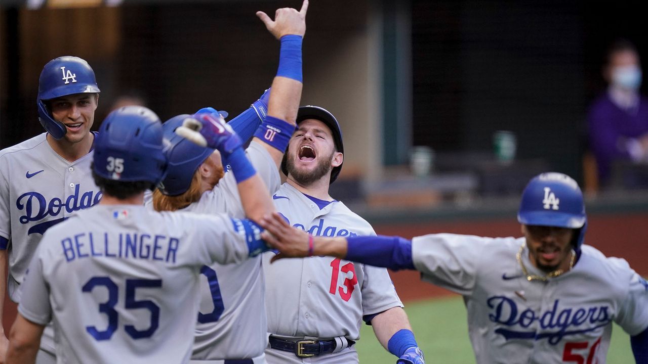 Los Angeles Dodgers' Max Muncy (13) celebrates his grand slam home run during the first inning in Game 3 of a baseball National League Championship Series against the Atlanta Braves Wednesday, Oct. 14, 2020, in Arlington, Texas. (AP Photo/Eric Gay)