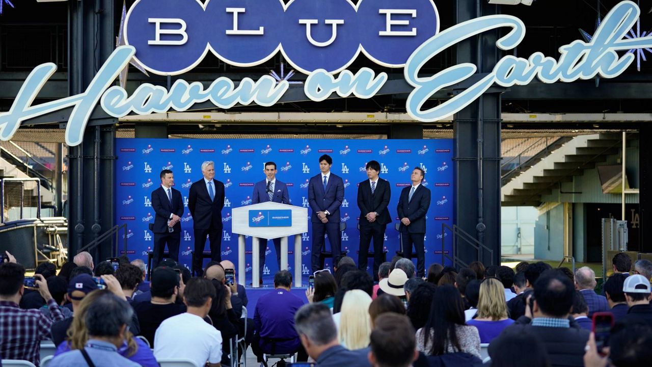 Los Angeles Dodgers' Shohei Ohtani, center right, is presented during a baseball news conference at Dodger Stadium Thursday in LA. (AP Photo/Ashley Landis)