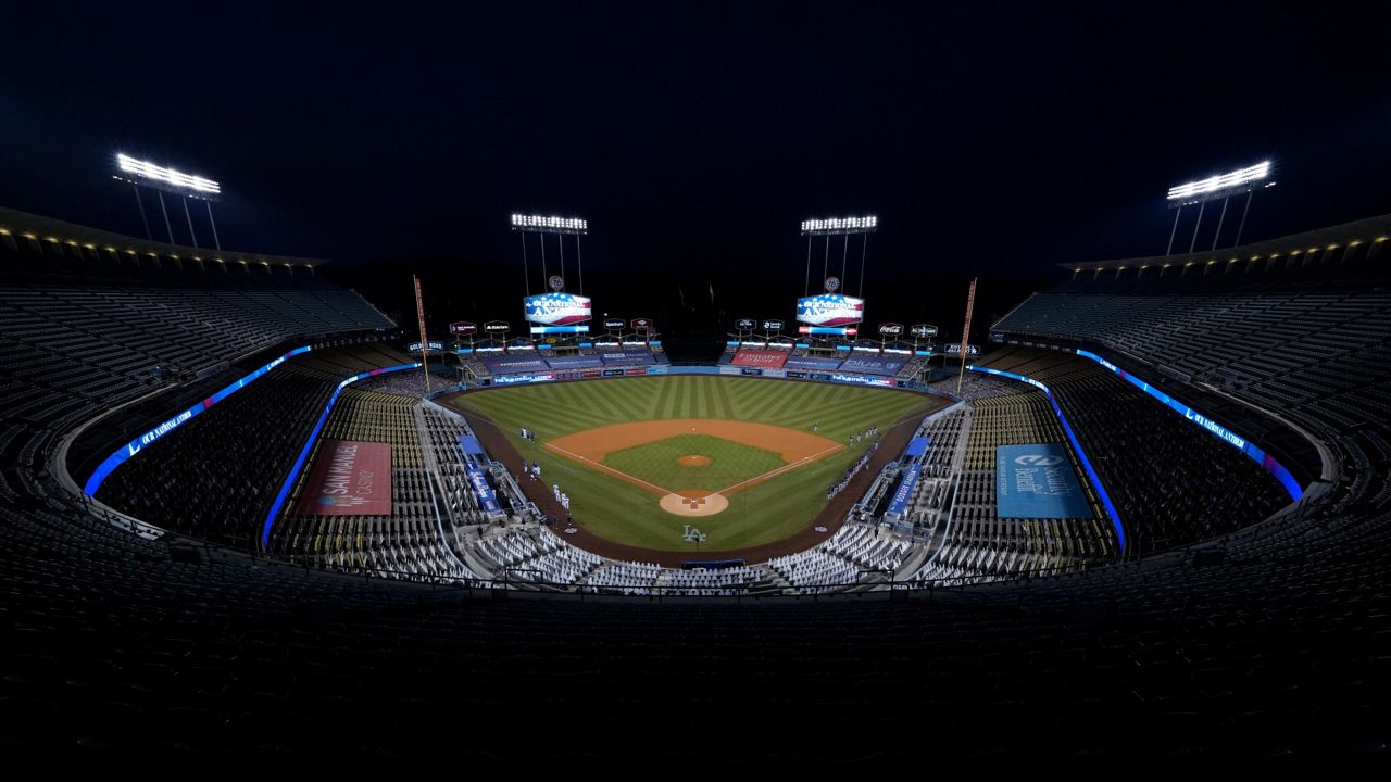 Dodger Stadium is seen without fans as the national anthem is played before Game 1 of a National League wild-card baseball series between the Los Angeles Dodgers and the Milwaukee Brewers on Wednesday, Sept. 30, 2020, in Los Angeles. (AP Photo/Ashley Landis)