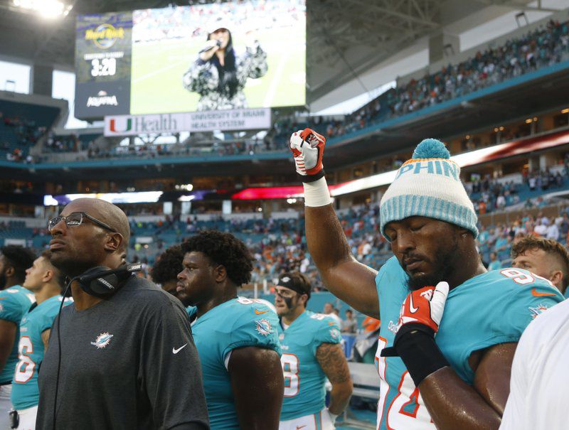 Miami Dolphins defensive end Robert Quinn (94) raises his right fist during the singing of the national anthem, before the team’s NFL preseason football game against the Tampa Bay Buccaneers, Thursday, Aug. 9, 2018, in Miami Gardens, Fla. (AP Photo/Wilfredo Lee)