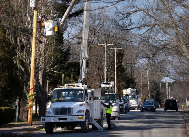 Crews from Irby Construction Co., of Mississippi, work to repair power lines along Maine Street in Kennebunkport after a storm that struck Maine Dec. 23. Gregory Rec/Staff Photographer	