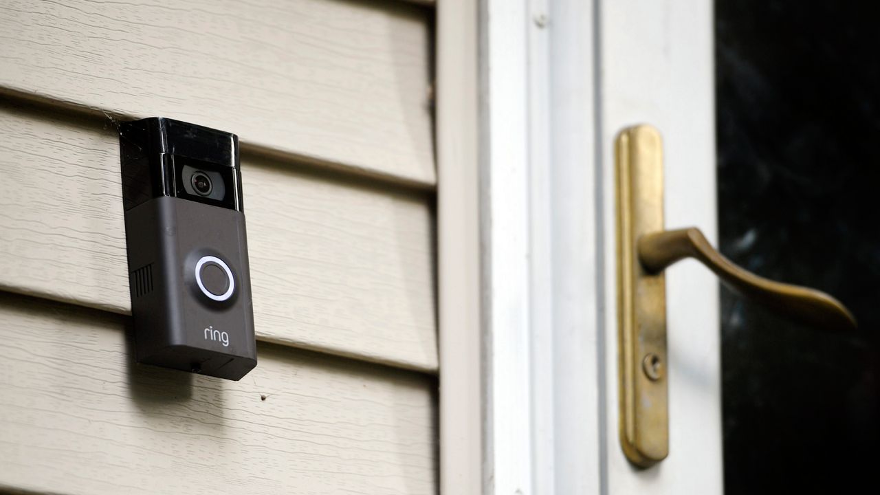 A Ring doorbell camera is seen installed outside a home. 