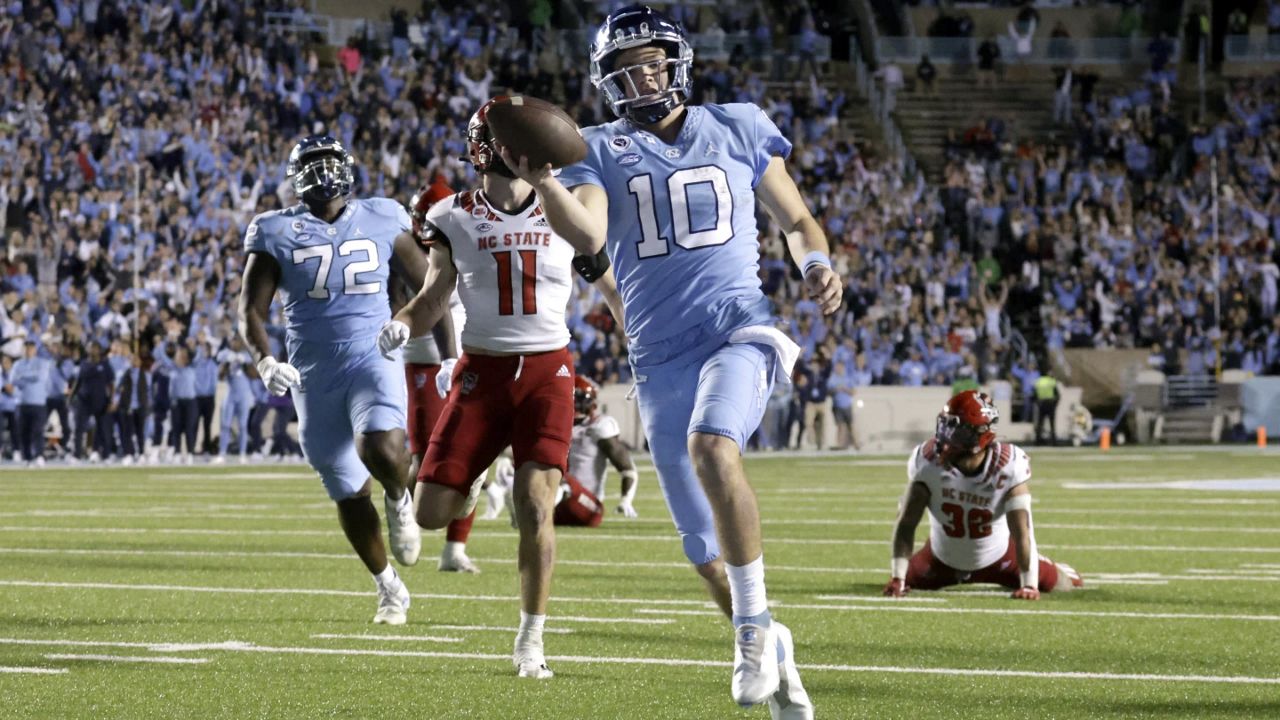 North Carolina quarterback Drake Maye (10) rolls into the end zone for a touchdown as North Carolina State linebacker Payton Wilson (11) trails during the second half of an NCAA college football game Nov. 25, 2022, in Chapel Hill, N.C. Maye has made a rapid rise to stardom to be a top NFL quarterback prospect and a Heisman Trophy candidate. (AP Photo/Chris Seward, File)