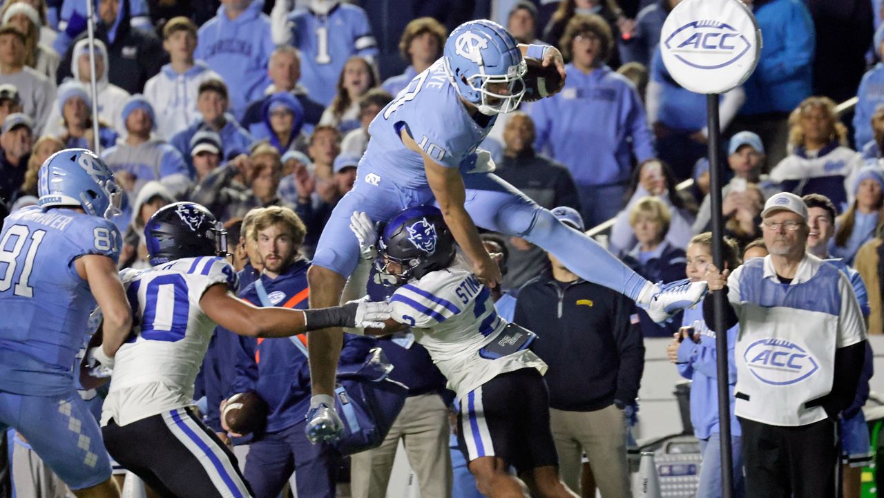 North Carolina quarterback Drake Maye (10) tries to hurdle Duke safety Jaylen Stinson (2) during the second half of an NCAA college football game Saturday, Nov. 11, 2023, in Chapel Hill, N.C. (AP Photo/Chris Seward)
