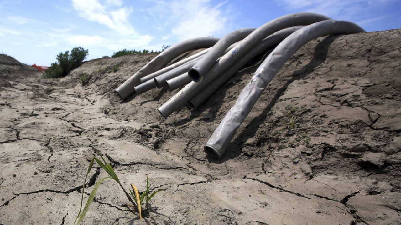 FILE - In this May 18, 2015 file photo, irrigation pipes sit along a dry irrigation canal on a field near Stockton, Calif. (AP Photo/Rich Pedroncelli, File)