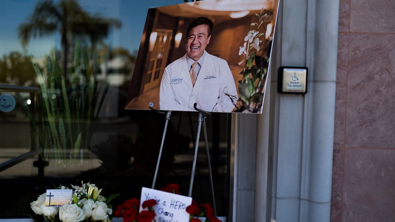 A photo of Dr. John Cheng, a 52-year-old victim who was killed in Sunday's shooting at Geneva Presbyterian Church, is displayed outside his office in Aliso Viejo, Calif., Monday, May 16, 2022. (AP Photo/Ashley Landis)