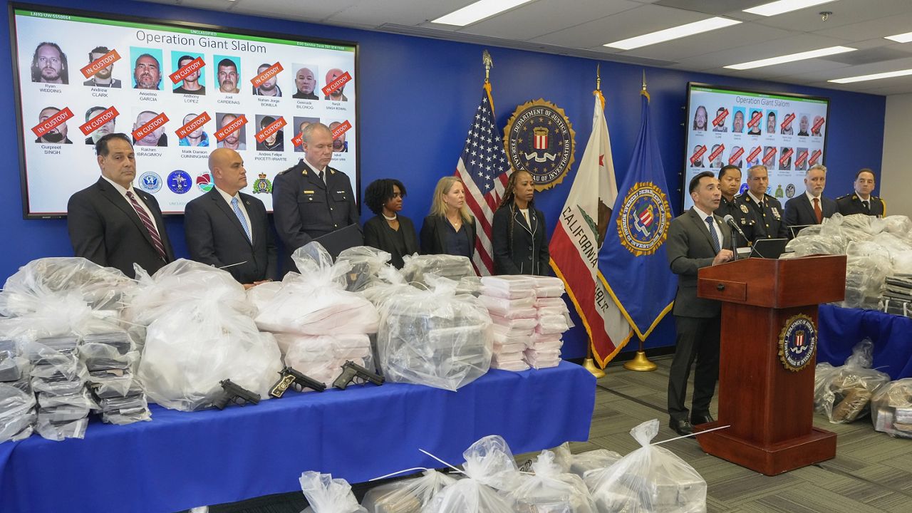 United States Attorney Martin Estrada, right at podium, joined by federal, local, and international officials, announces federal charges and arrests of alleged members of a transnational drug trafficking operation that routinely shipped hundreds of kilograms of cocaine from Colombia, through Mexico and Southern California, to Canada and other locations in the United States, during a news conference at the FBI offices in Los Angeles, Thursday, Oct. 17, 2024. (AP Photo/Damian Dovarganes)