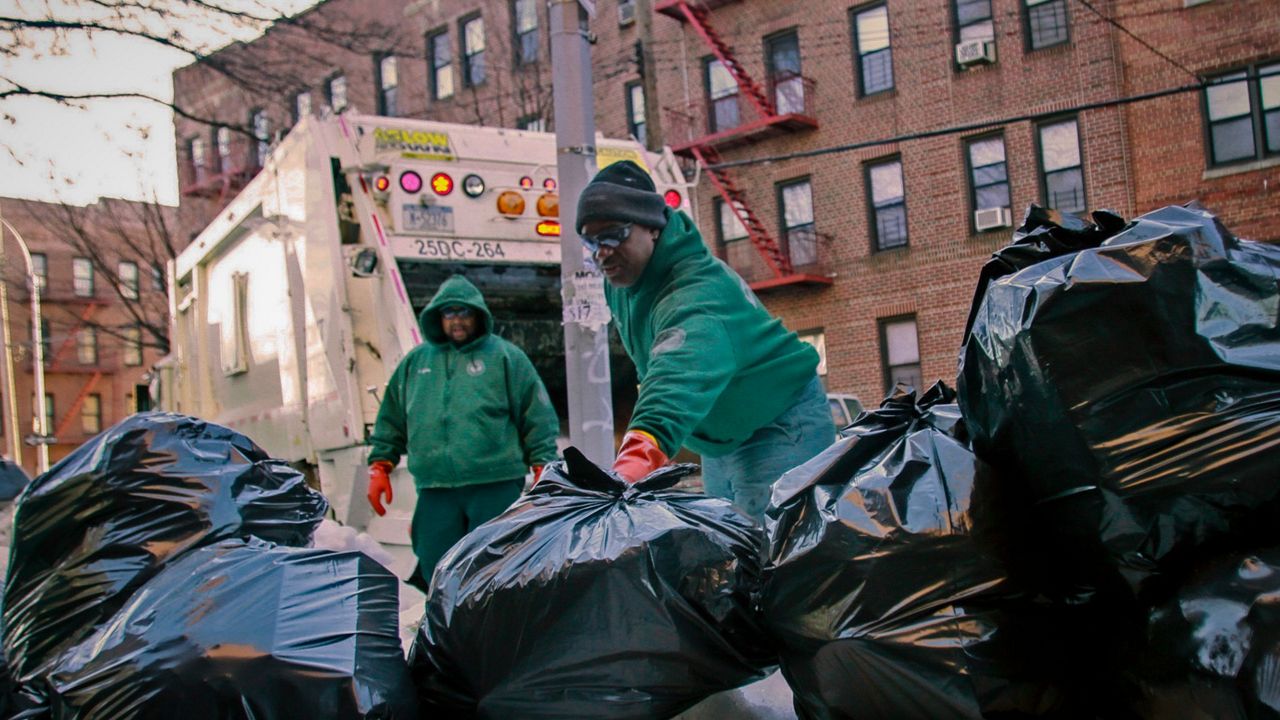 New York City sanitation workers pickup garbage in he Flatbush section of Brooklyn, N.Y.