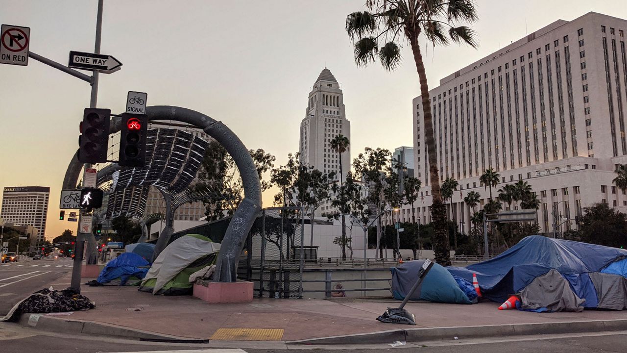 Homeless people camp downtown in Los Angeles on Friday, March 27, 2020. On Friday, California Gov. Gavin Newsom and Los Angeles Mayor Eric Garcetti said the surge in COVID-19 that health officials warned about will worsen. (AP Photo/Damian Dovarganes)