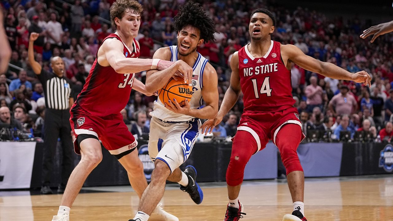 Duke's Jared McCain, center, drives against North Carolina State's Ben Middlebrooks (34) and Casey Morsell (14) during the second half of an Elite Eight college basketball game in the NCAA Tournament in Dallas, Sunday, March 31, 2024. (AP Photo/Tony Gutierrez)