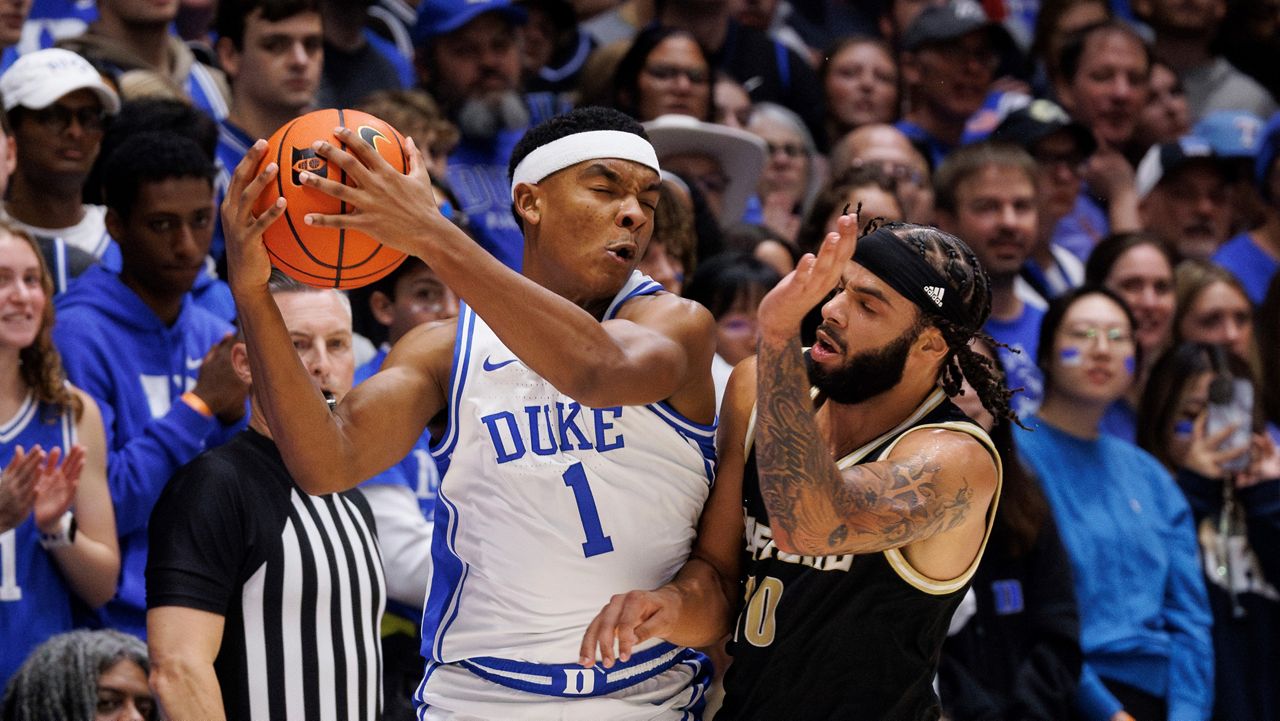 Duke's Caleb Foster (1) is bumped by Wofford's Corey Tripp (10) during the first half of an NCAA college basketball game in Durham, N.C., Saturday, Nov. 16, 2024. (AP Photo/Ben McKeown)