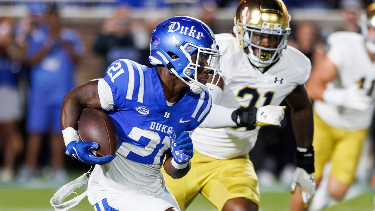 Duke's Peyton Jones (21) carries the ball ahead of Notre Dame's Nana Osafo-Mensah (31) during an NCAA college football game in Durham, N.C., on Saturday, Sept. 30, 2023. (AP Photo/Ben McKeown)