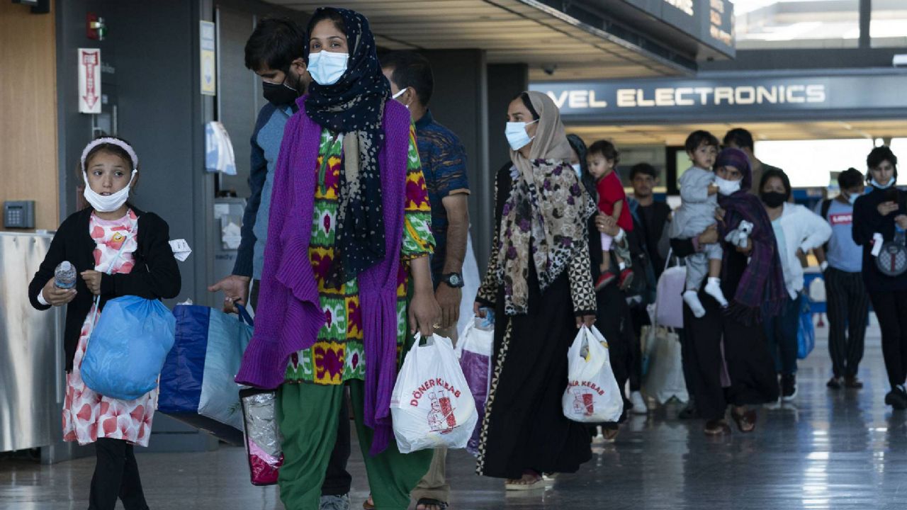Families evacuated from Kabul, Afghanistan, walk through the terminal before boarding a bus after they arrived at Washington Dulles International Airport, in Chantilly, Va., on Friday. (AP Photo/Jose Luis Magana)