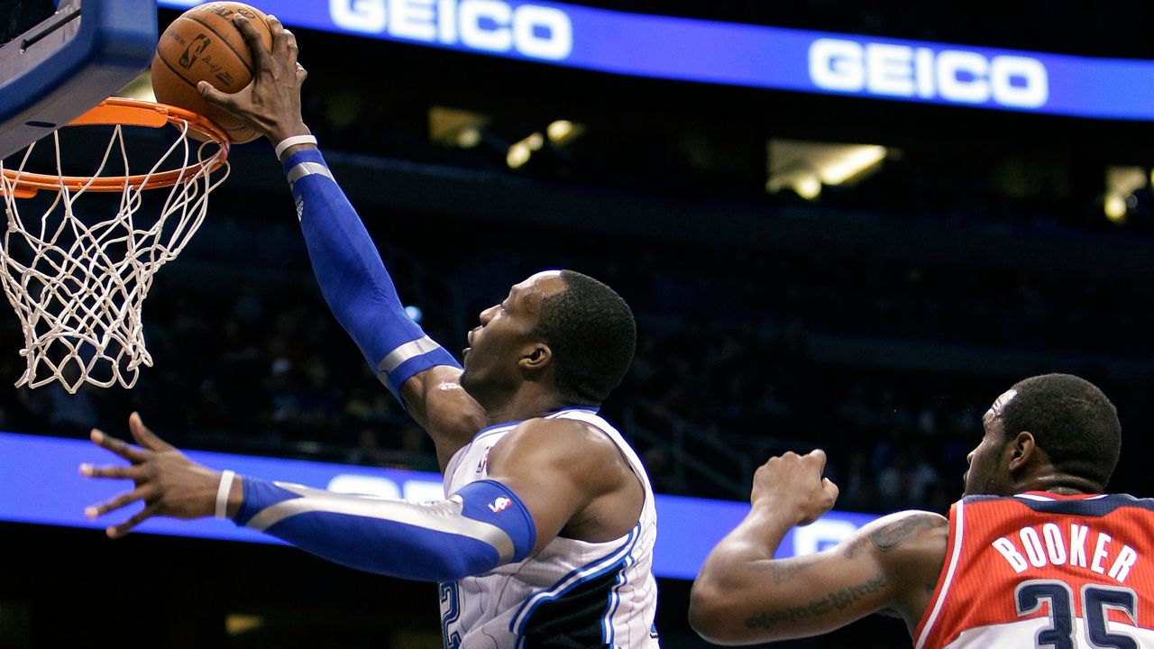 Orlando Magic's Dwight Howard, left, dunks the ball in front of Washington Wizards' Trevor Booker (35) during the second half of an NBA basketball game Wednesday, Feb. 1, 2012, in Orlando, Fla. Orlando won 109-103. (AP Photo/John Raoux)