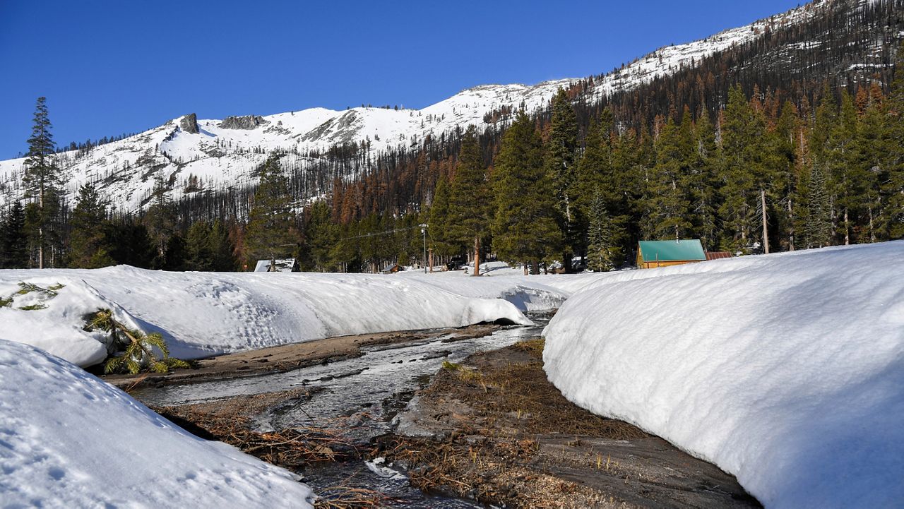 In this photo provided by the California Department of Water Resources, snow melts into a creek flowing into the South Fork American River, near where the California Department of Water Resources held the second snow survey of the season at Phillips Station near Echo Summit, Calif., Tuesday, Feb. 1, 2022. (Kenneth James/California Department of Water Resources via AP)