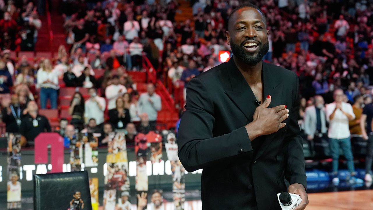 Former Miami Heat NBA basketball player Dwyane Wade puts his hand over his heart to acknowledge the crowd during a halftime ceremony 