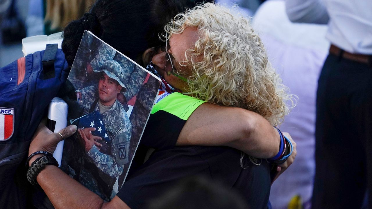 People react as they attend a ceremony marking the 20th anniversary of the Sept. 11, 2001, terrorist attacks at the National September 11 Memorial and Museum in New York, Saturday, Sept. 11, 2021. (AP Photo/Evan Vucci)