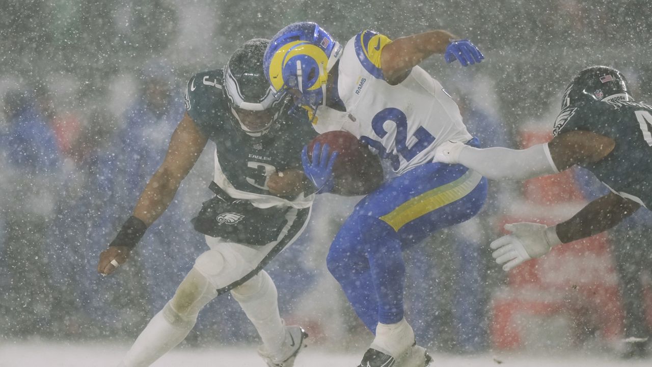 Los Angeles Rams running back Cody Schrader (32) is stopped with the ball by Philadelphia Eagles linebacker Nolan Smith Jr. (3) and Philadelphia Eagles linebacker Nicholas Morrow, right, during the second half of an NFL football NFC divisional playoff game Sunday, Jan. 19, 2025, in Philadelphia. (AP Photo/Matt Slocum)