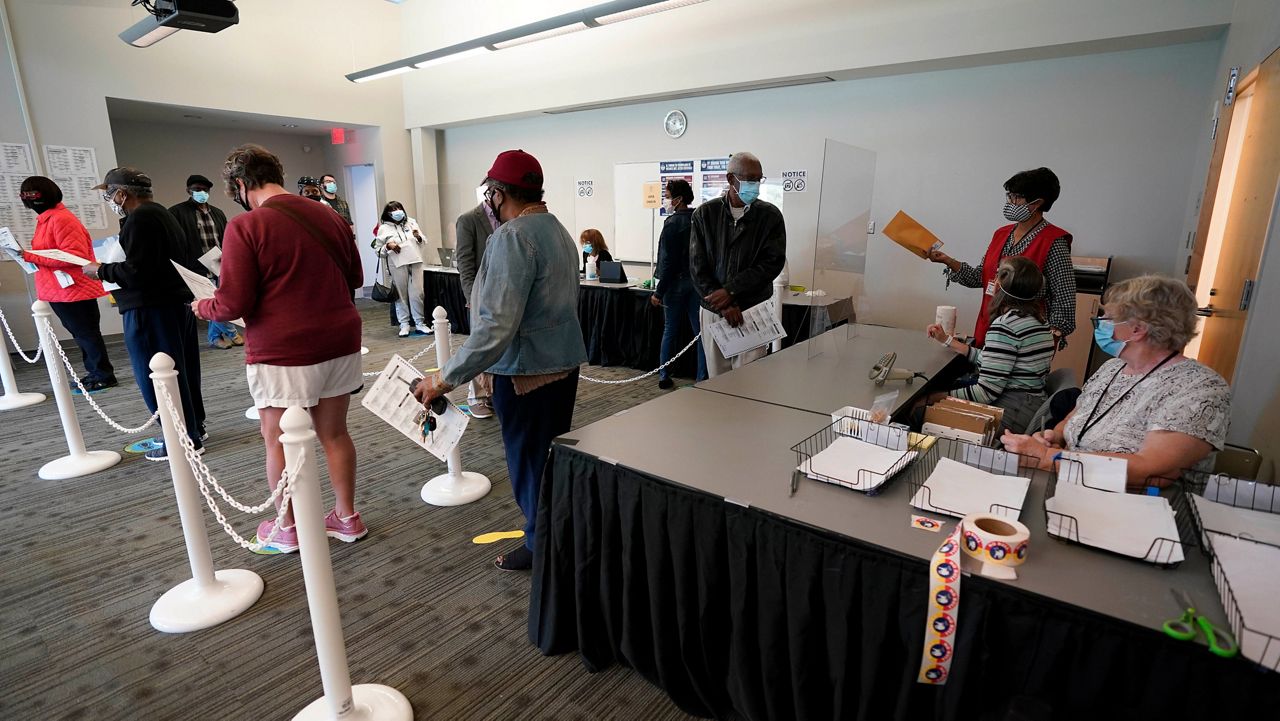 Early voters line up to cast ballots at the South Regional Library in Durham, N.C., on Thursday, Oct. 15, 2020. (AP Photo/Gerry Broome, File)