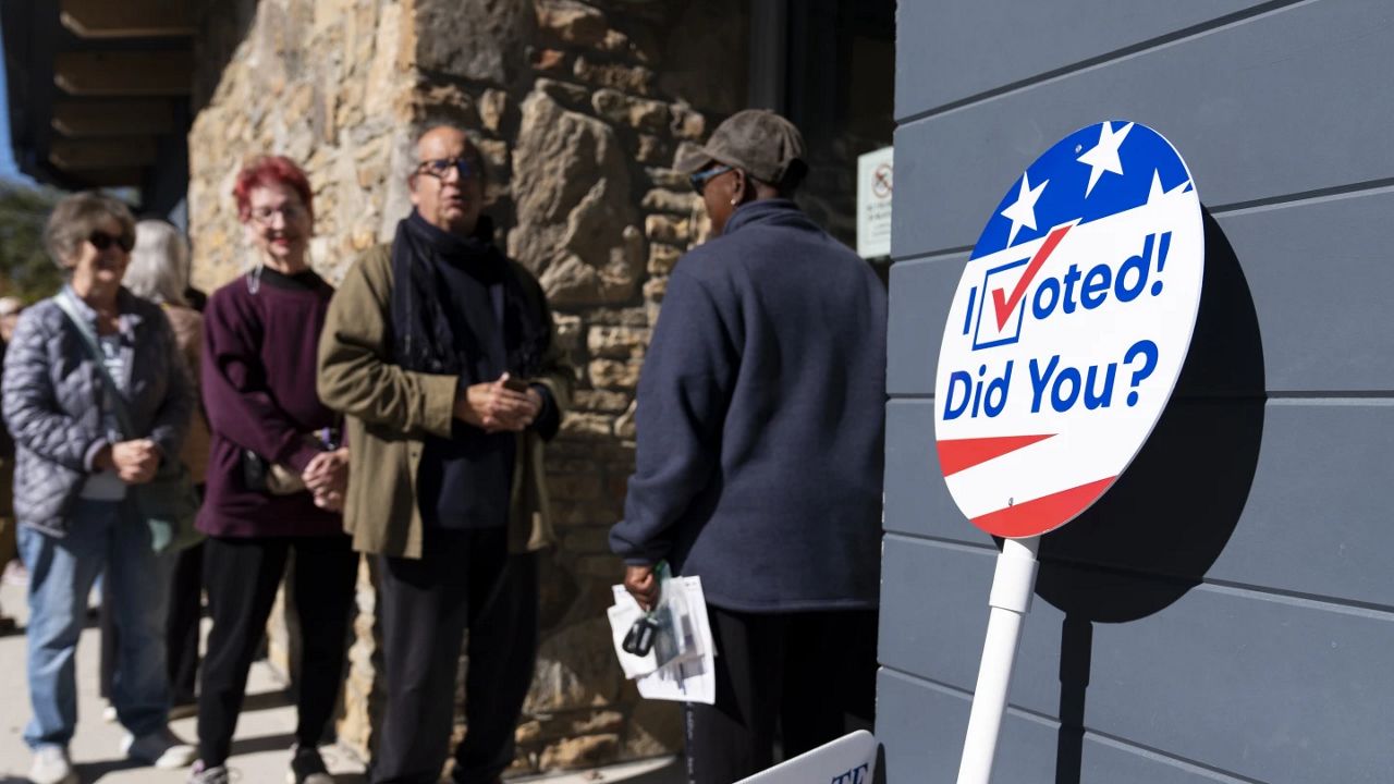 People wait in line at a polling place during the first day of early in-person voting in Asheville, N.C., Thursday, Oct. 17, 2024. (AP Photo/Stephanie Scarbrough)