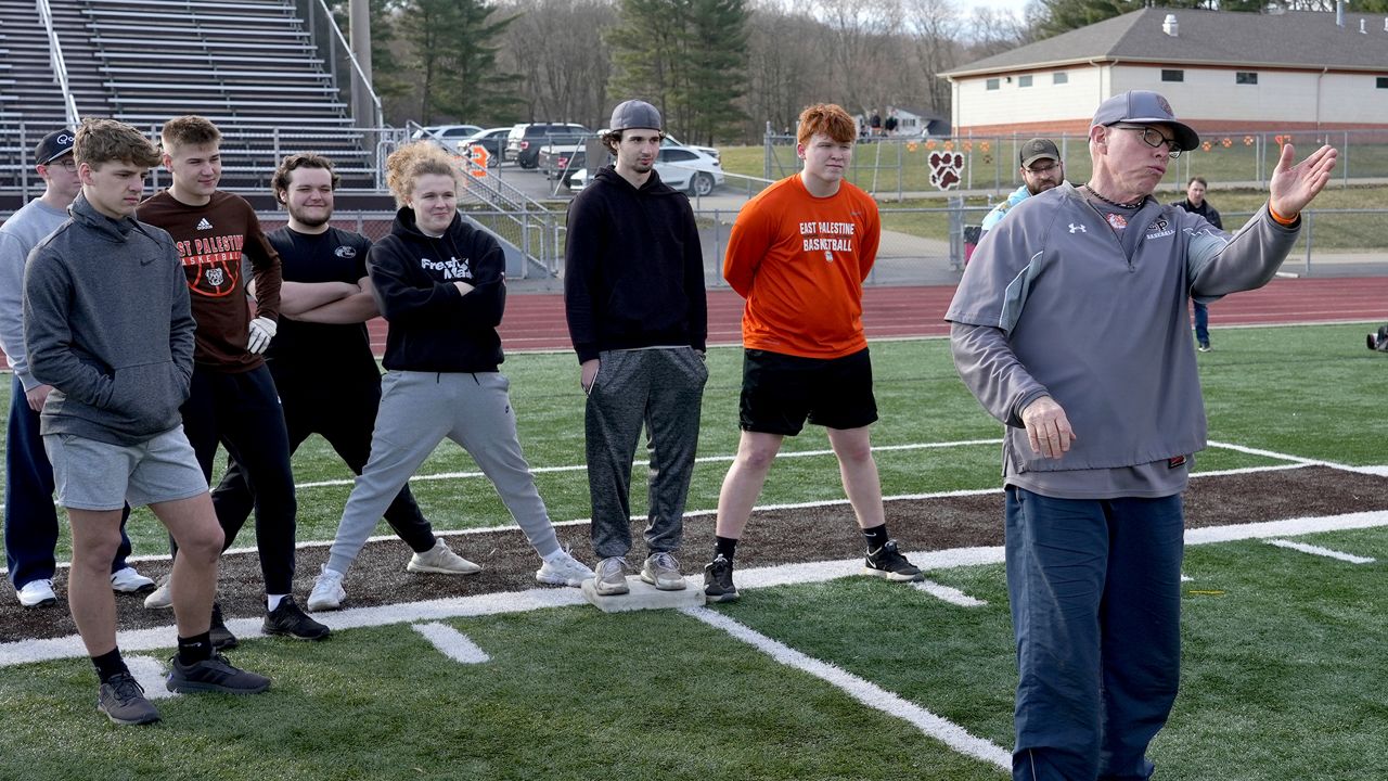 East Palestine High School baseball coach Bill Sattler instructs his team during practice, Monday, March 6, 2023, in East Palestine, Ohio. Athletes are navigating spring sports following the Feb. 3 Norfolk Southern freight train derailment. (AP Photo/Matt Freed)