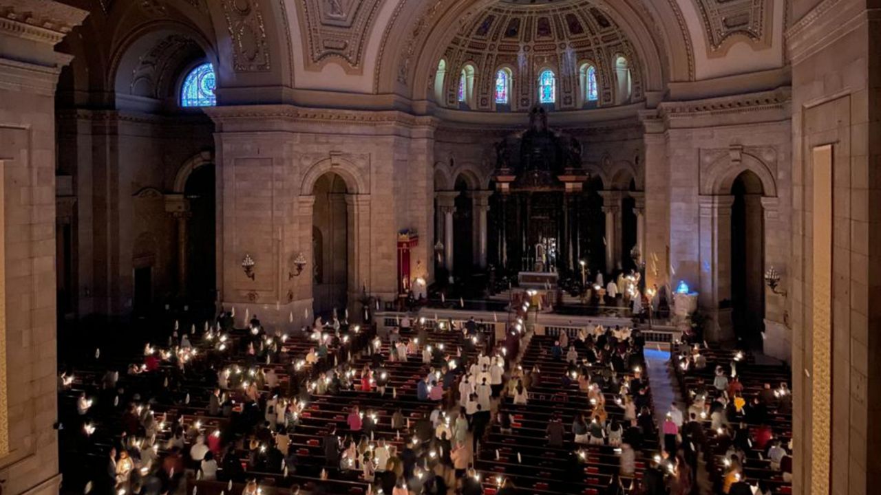 Hundreds of people light candles at the beginning of the Easter Vigil Mass at the Cathedral of St. Paul in St. Paul, Minn., on Saturday, April 16, 2022. For many U.S. Christians, this weekend marks the first time since 2019 that they will gather in person on Easter Sunday, a welcome chance to celebrate one of the year's holiest days side by side with fellow congregants. (AP Photo/Giovanna Dell'Orto)