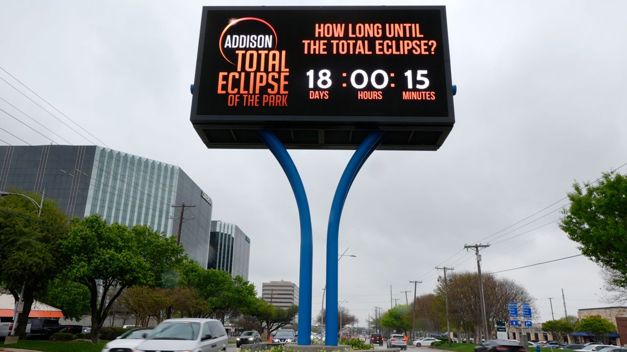 Information regarding the total solar eclipse is shown on a digital billboard as drivers make their way down a busy road in Addison, Texas, Thursday, March 21, 2024. (AP Photo/Tony Gutierrez)