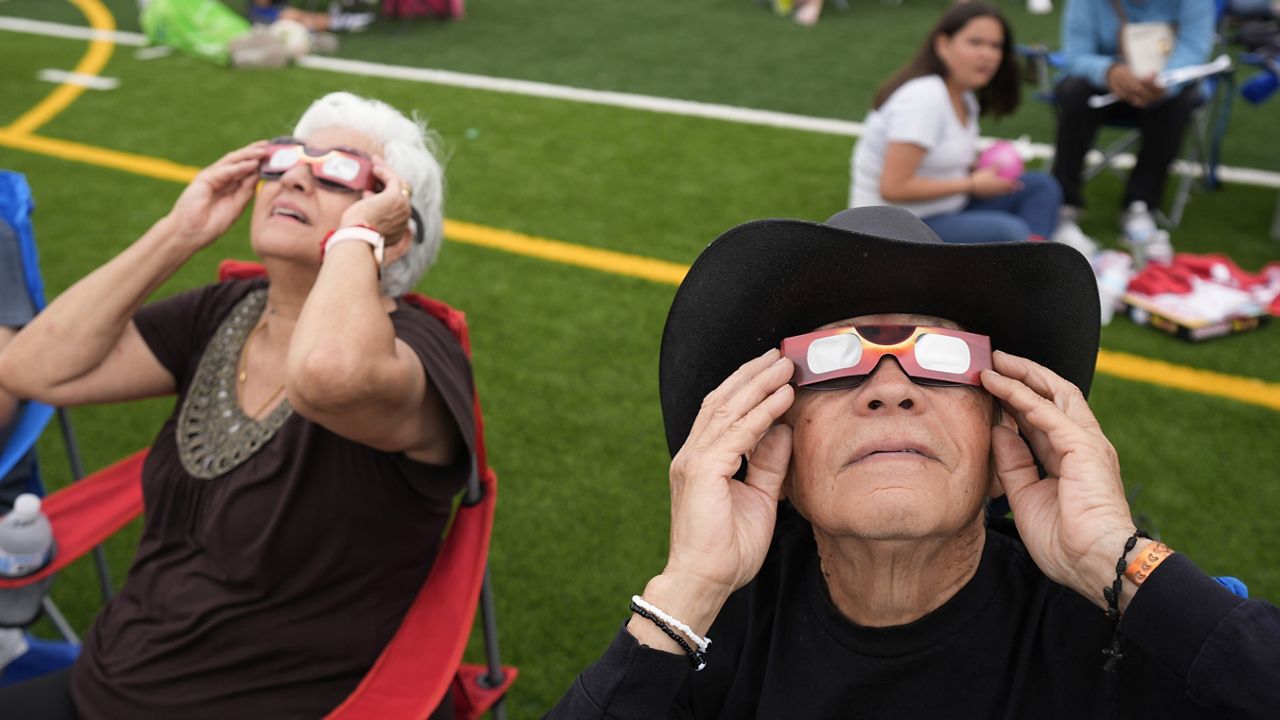 Al Angel Flores, 79, uses special glasses to watch as the moon partially covers the sun during a total solar eclipse, as seen from Eagle Pass, Texas, Monday, April 8, 2024. (AP Photo/Eric Gay)