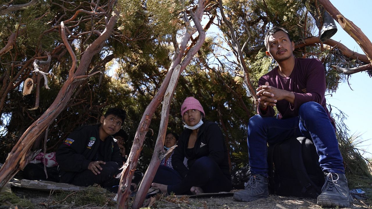 A group of asylum-seekers from Ecuador wait in a makeshift camp after crossing the nearby border with Mexico, Wednesday, Sept. 20, 2023, near Jacumba Hot Springs, Calif. Migrants continue to arrive to desert campsites along California's border with Mexico, as they await processing in tents made from tree branches. (AP Photo/Gregory Bull)