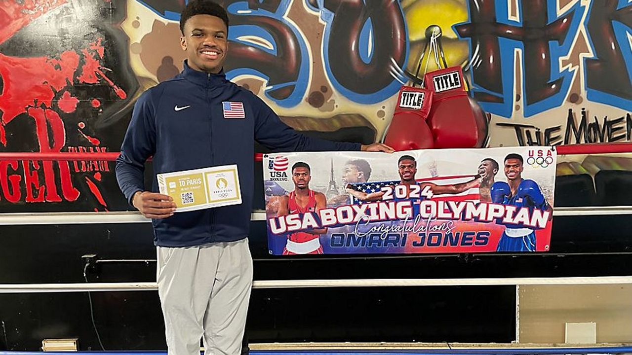 Omari Jones poses with his Paris 2024 Olympics qualifying ticket. (Spectrum Sports/Danielle Stein)