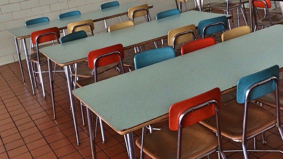 Tables and chairs in a school cafeteria appear in this stock image. (Pixabay)