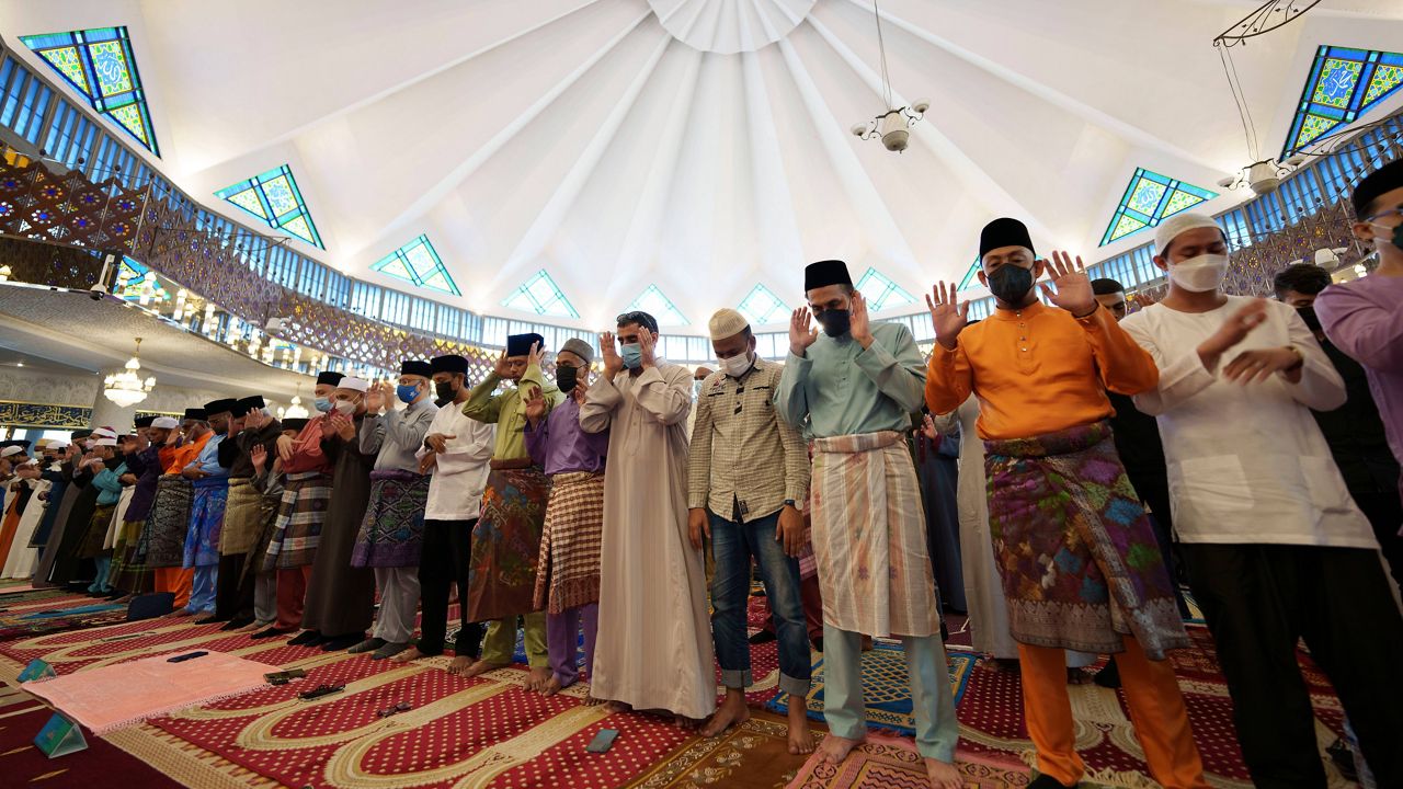 Muslims wearing protective masks pray Monday, on Islamic holiday of Eid al-Fitr, at the National Mosque in Kuala Lumpur, Malaysia. (AP Photo/Vincent Thian)