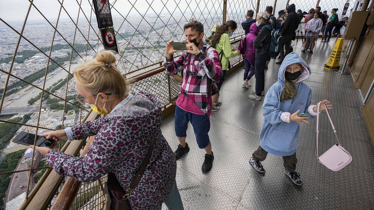 In this Friday, July 16, 2021 file photo, visitors enjoy the view from top of the Eiffel Tower in Paris. (AP Photo/Michel Euler, File)