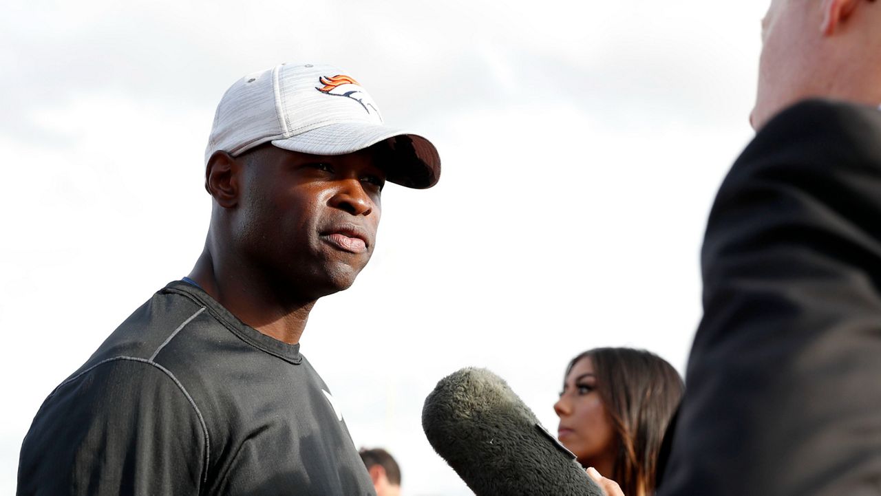 Denver Broncos defensive coordinator Ejiro Evero, left, speaks with media after a practice session in Harrow, England, Oct. 28, 2022. (AP Photo/Steve Luciano, File)