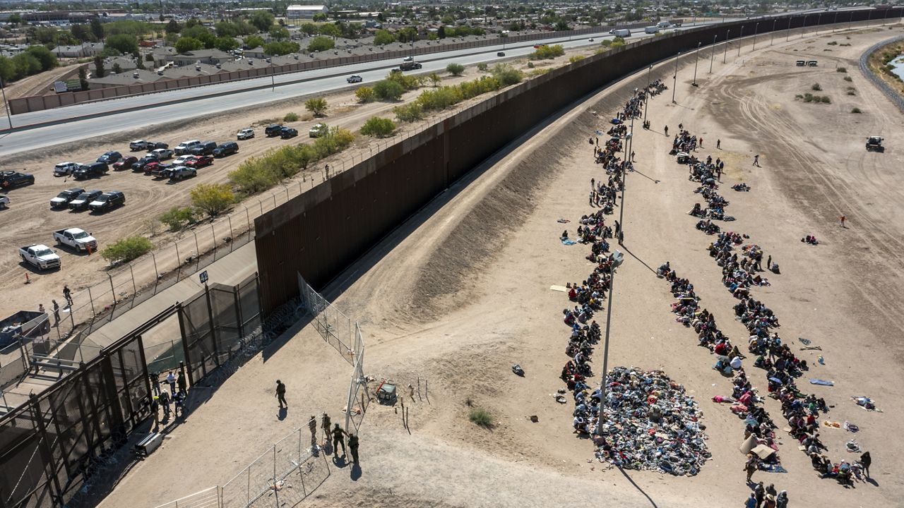 Migrants form lines outside the border fence waiting for transportation to a U.S. Border Patrol facility in El Paso, Texas, May 10, 2023. (AP Photo/Andres Leighton, File)