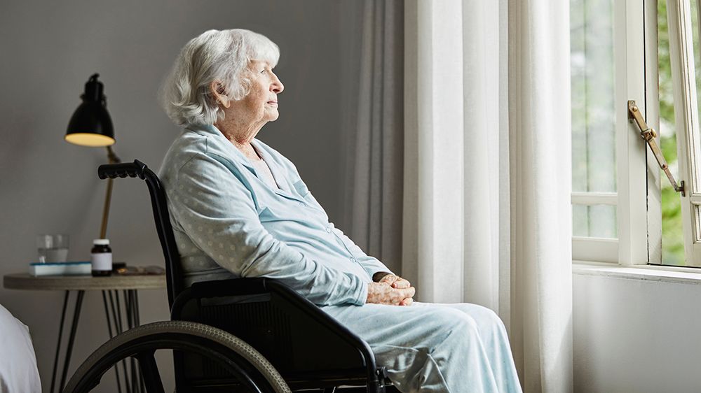 A woman in a wheelchair stares out the window. (Getty Images)